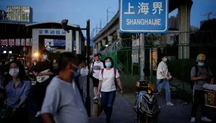 Pessoas usando máscara de proteção facial caminham em Xangai, na China.