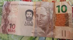 Imagem ilustrativa da imagem Manifestantes carimbam notas com a mensagem "Lula Livre" e o rosto do ex-presidente