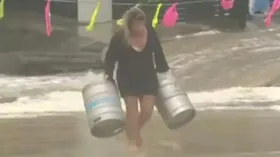 Imagem ilustrativa da imagem Mulher se joga ao mar para salvar barris de cerveja arrastados por chuva; veja o vídeo