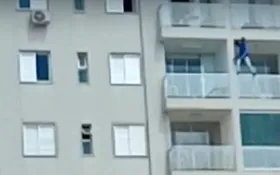 Imagem ilustrativa da imagem Homem se arrisca ao ficar em pé na grade de apartamento